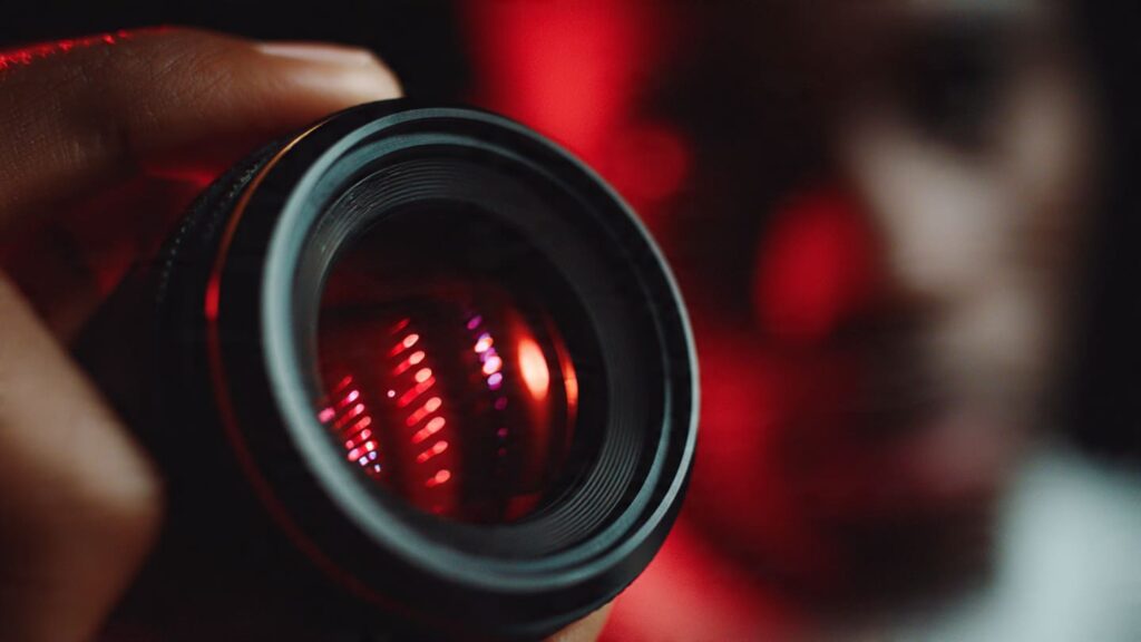 Professional camera setup with a red ring light reflecting in a smartphone lens, focusing on high-quality video production for Nigerian creators.