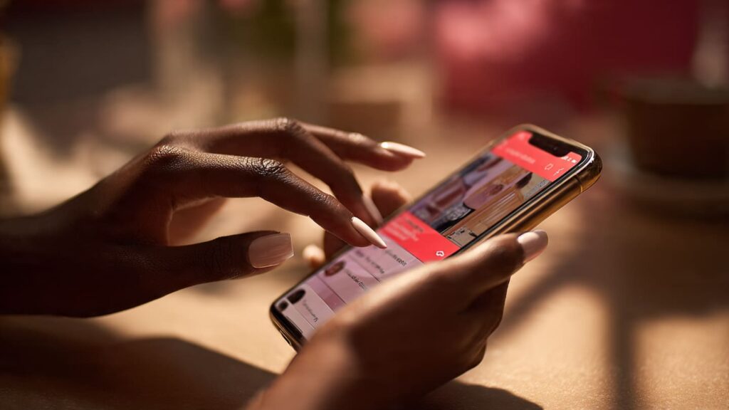 Close-up of a Nigerian woman’s hands using a poll sticker on a phone to drive Instagram Story engagement strategies in Lagos.
