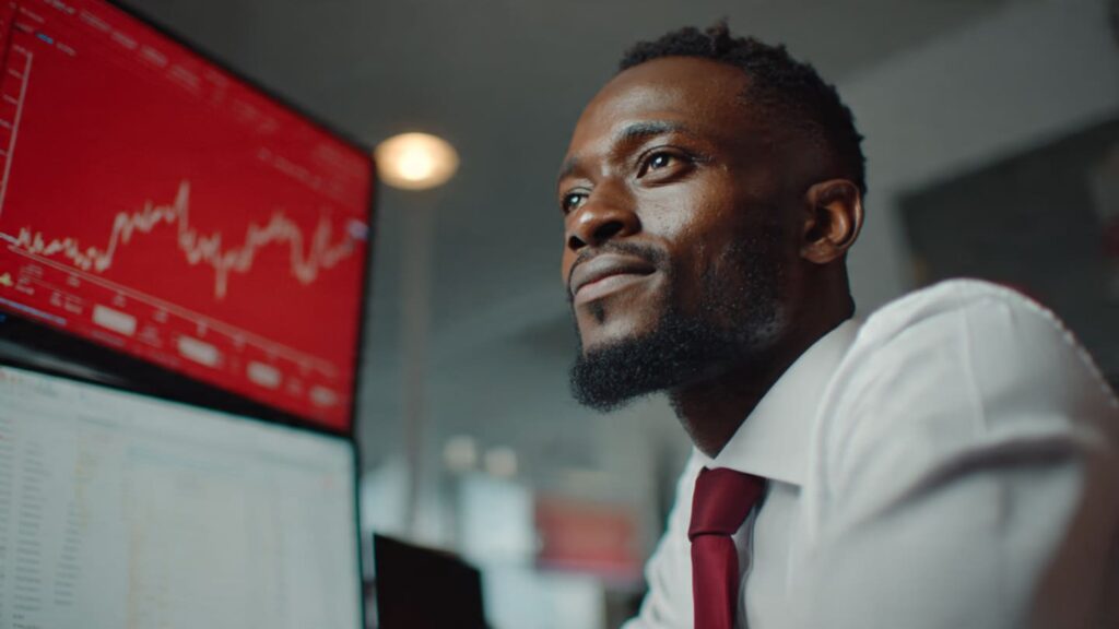 A confident Nigerian man using a laptop in an Abuja workspace to grow profile traffic Instagram using professional scaling tools.