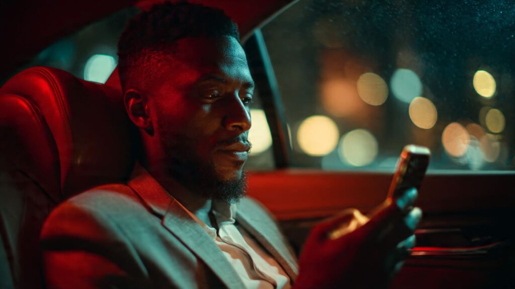 A Nigerian professional checking their phone during a commute to find the best time to post on Instagram in Nigeria.